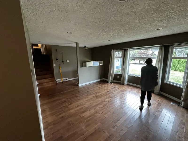 The original dining area with dark hardwood floors and a textured ceiling