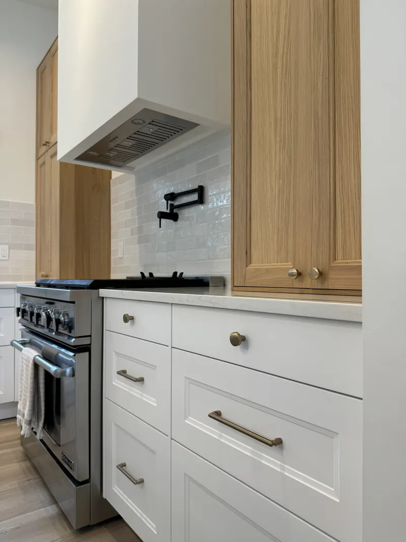 Six burner range with a zellige tile backsplash, pot filler and red oak cabinetry