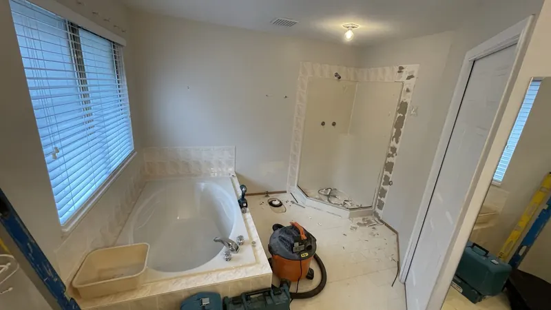 The old drop-in tub and neo angle shower during demolition