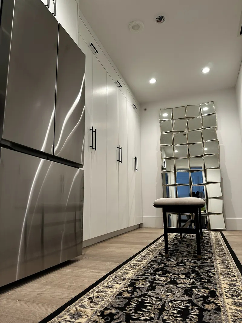 Converted dressing room with custom wardrobes and space for the spare refrigerator