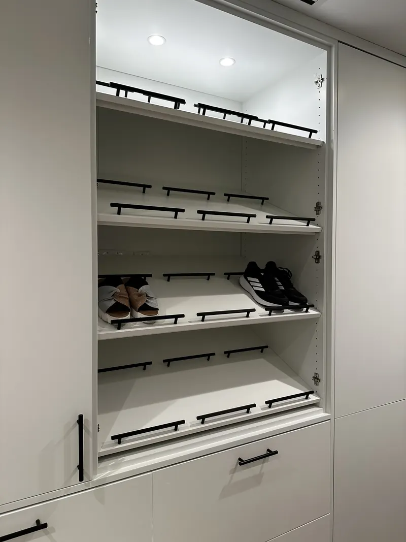 Existing open shelving repurposed and painted for shoe storage