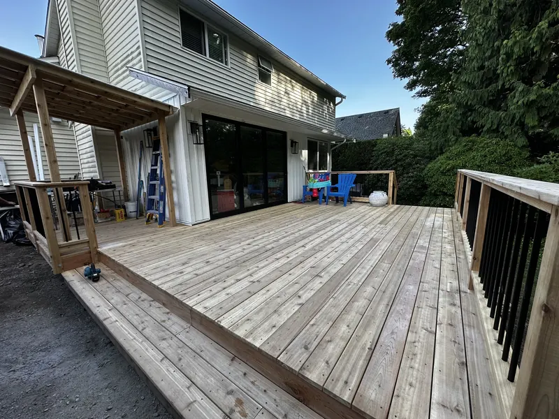 New cedar deck with black railings and a covered patio
