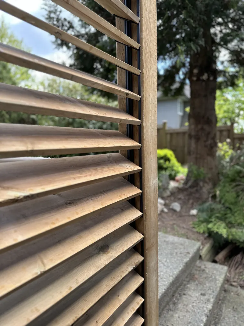 Cedar louvred privacy screen beside a garden path